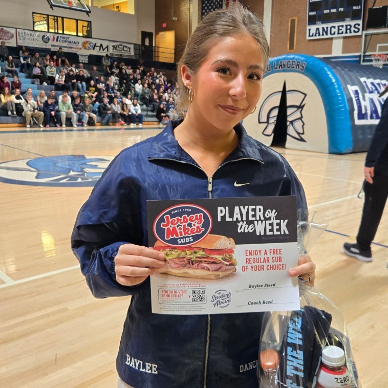 Baylee holding her athlete of the week award