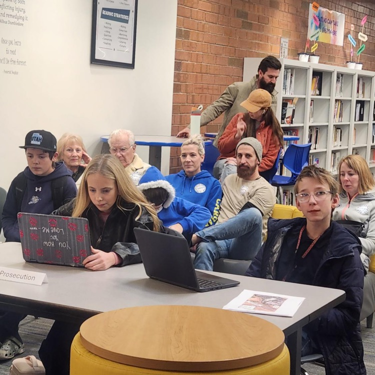 A group of students and parents on computers at a mock trial event