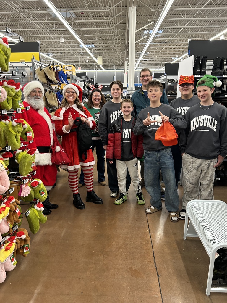 image of students in a shopping center with santa and mrs. claus and kjh principal