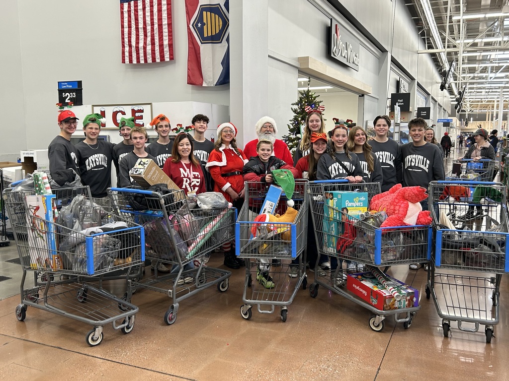 image of students with multiple shopping carts surrounding santa and mrs. claus