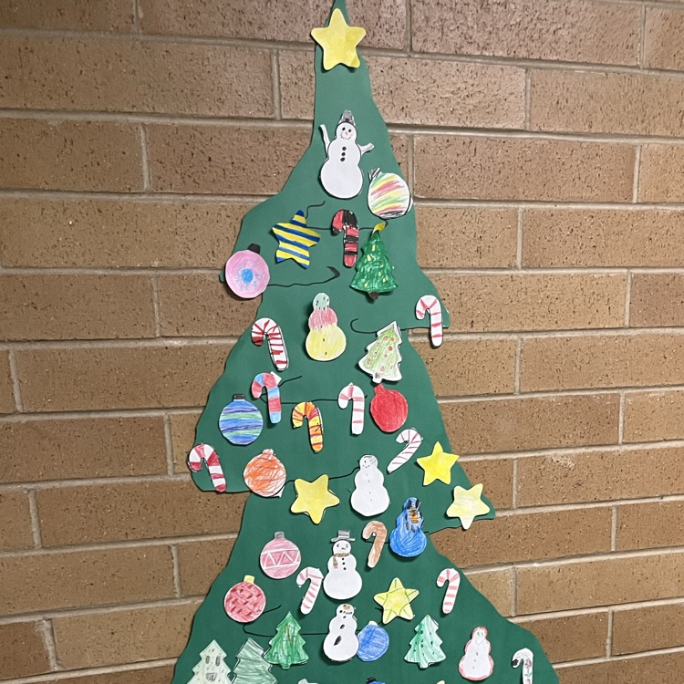 An image is shown displaying a Christmas tree decorated with student made Paper ornaments. 