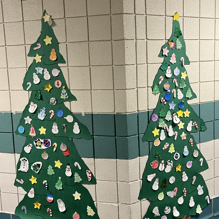 An image is shown displaying multiple Christmas trees decorated with student made Paper ornaments. 