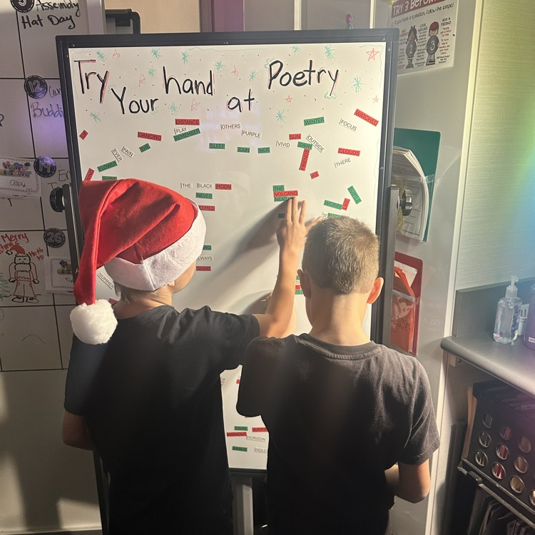 two boys at poetry board moving magnets
