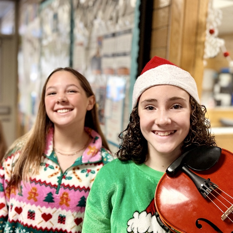 Orchestra students playing music in the hallway.