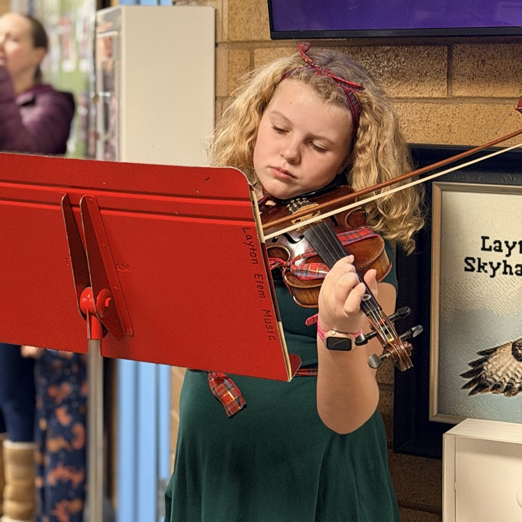 Orchestra students playing music in the hallway