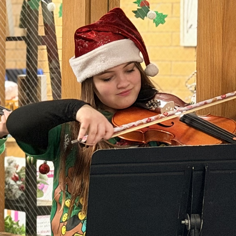 Orchestra students playing music in the hallway