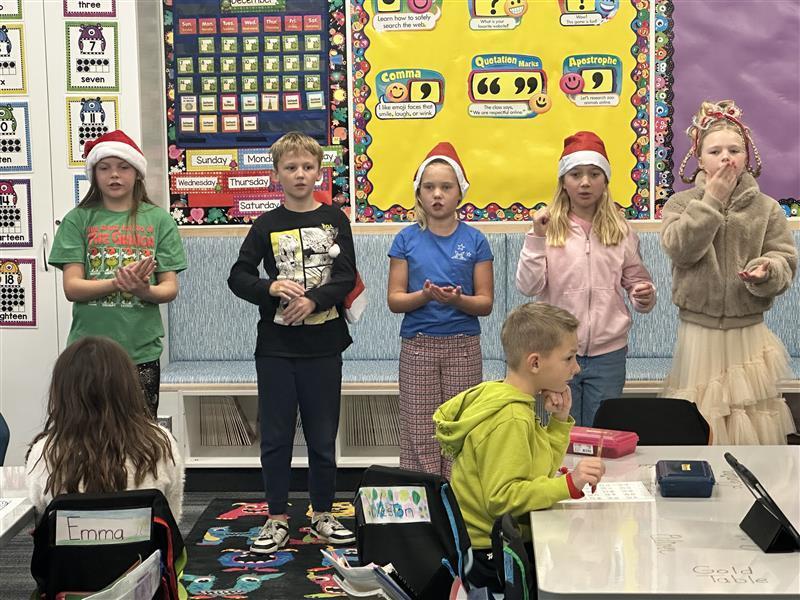 5 students using sign language in front of group