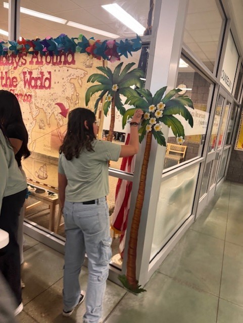 Student attached decoration on palm tree to celebrate Samoa