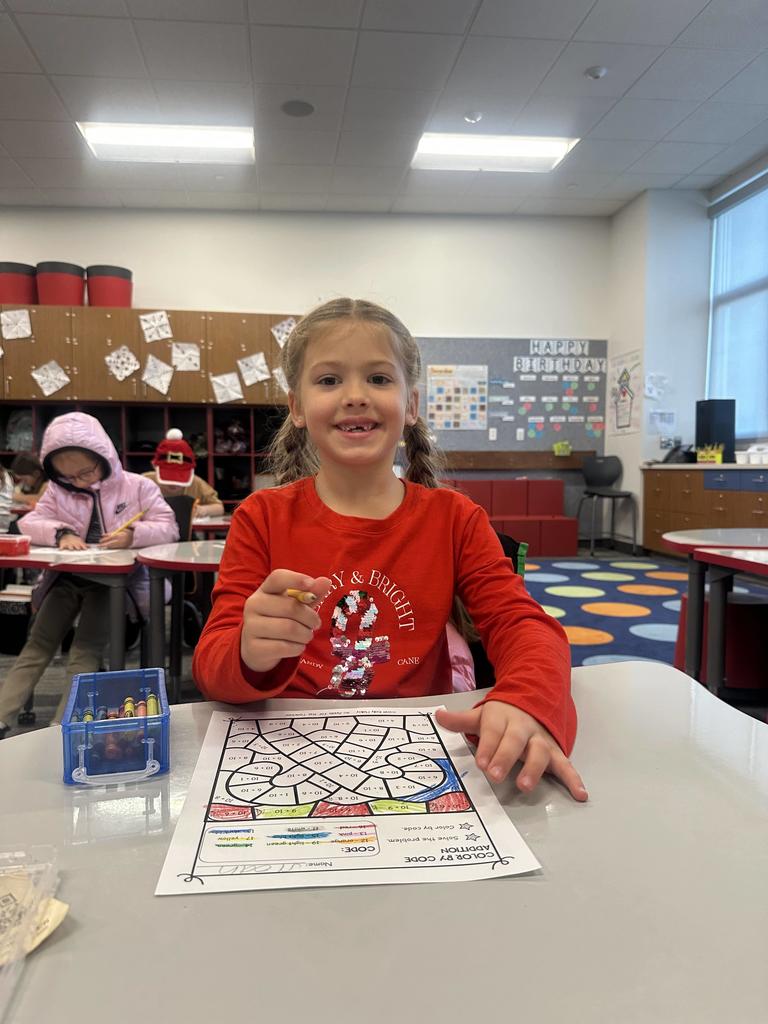 Student working on math wearing a Christmas shirt. 