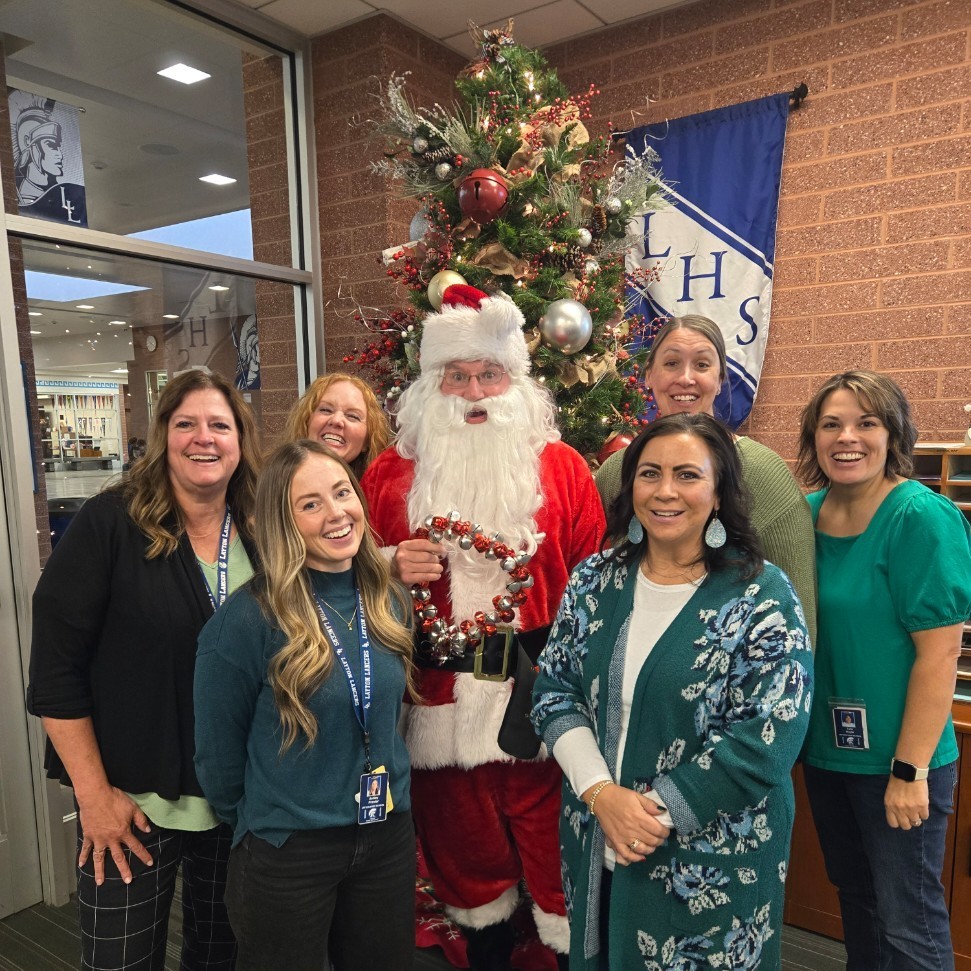 Santa and the secretaries posing for a picture