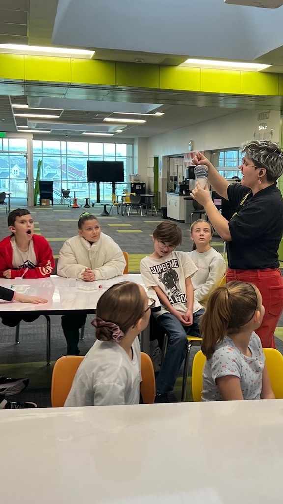 students watching a guest presenter demonstrating chemical reactions.