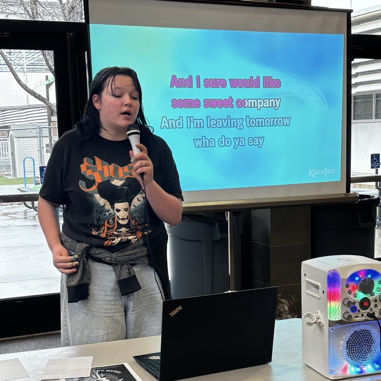 Student singing during a Karaoke party in the commons at lunch  