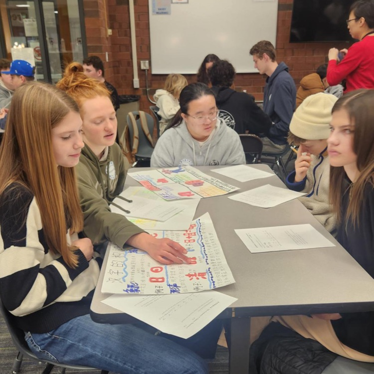 5 students sitting around a table working in a chinese project
