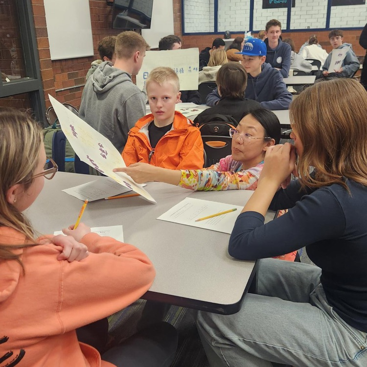 3 students learning from their chinese teacher