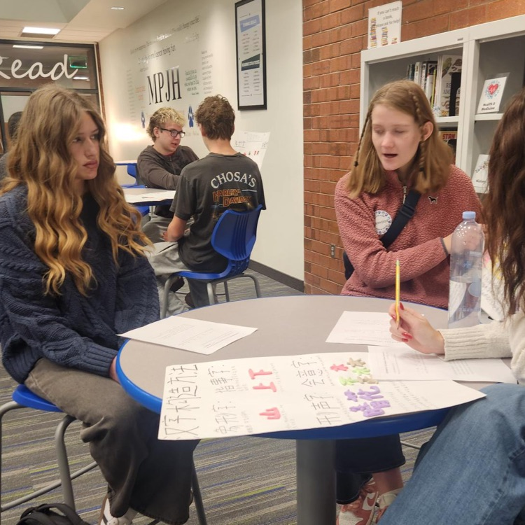 high school students teaching chinese to a junior high student