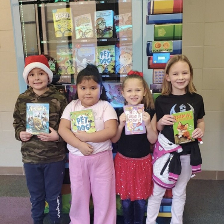 1st graders posing with books they got to spend a coin on at the book vending machine