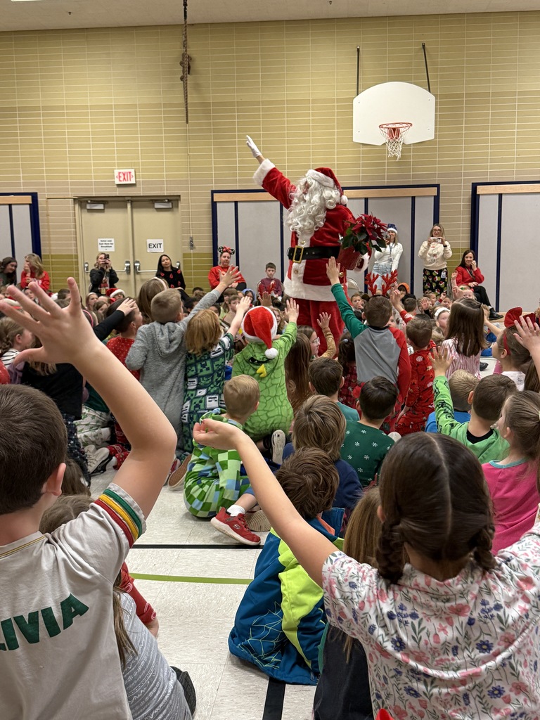 students gathered around santa claus in a christmas assembly