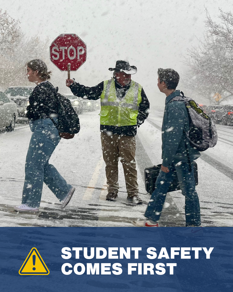 Crossing guard letting students cross the road. There is a hazard icon with the words "student safety comes first."