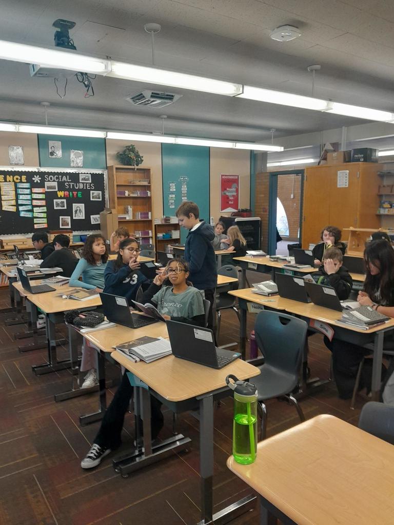 A classroom full of 5th graders working on their laptops to build powerpoints about The Reformation.
