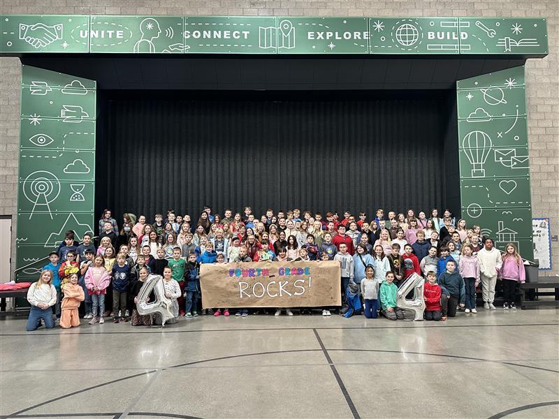 large group of students holding fourth grade rocks banner