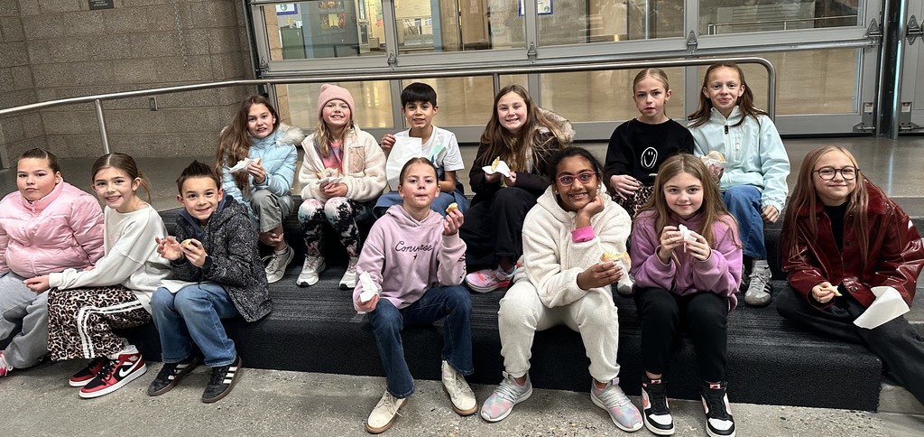 group of students eating donuts on steps