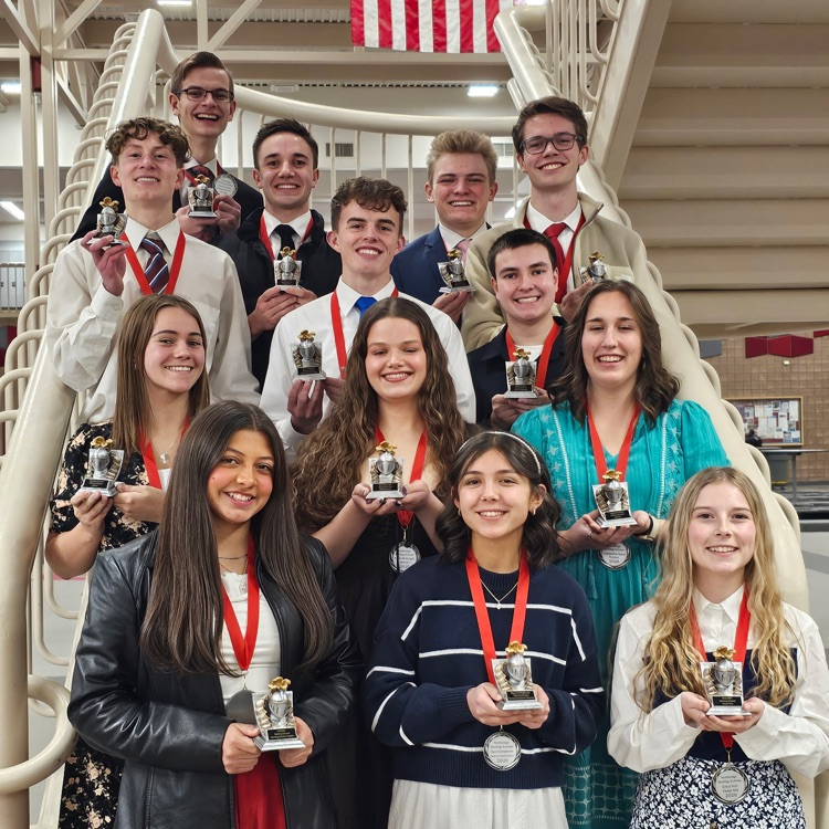 sterling scholar winners. students standing on a staircase with their trophies.