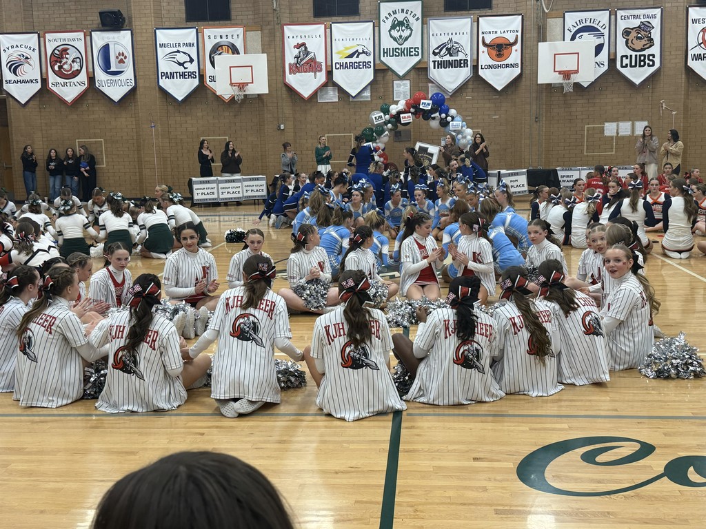 image of cheerleaders sitting in a circle holding hands
