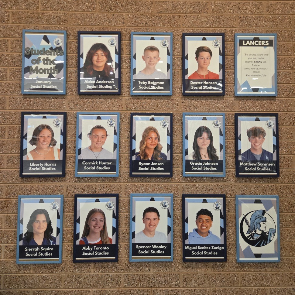 portraits of the twelve students of the month on the wall by the front doors of the school