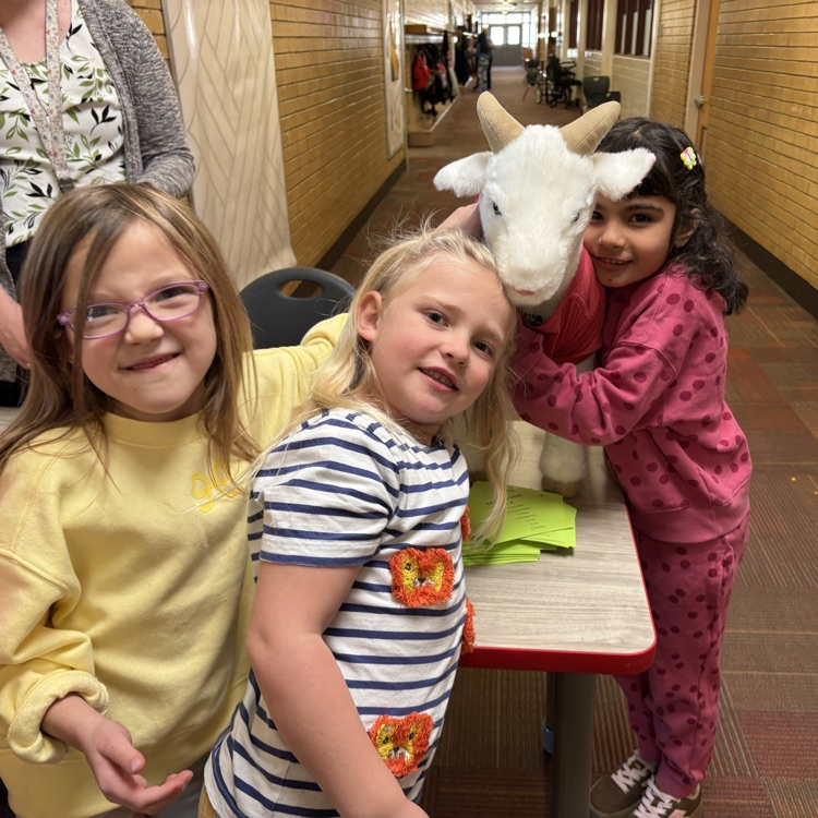 three students hugging ass stuffed goat animal
