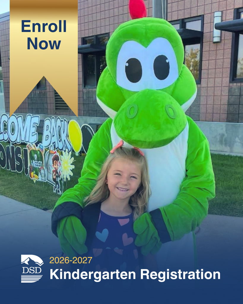 A smiling young girl stands in front of a friendly green dinosaur mascot outside a school building. A gold ribbon in the corner says "Enroll Now," and the bottom text reads "2026-2027 Kindergarten Registration" with the DSD logo.