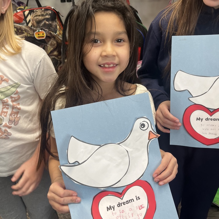 girl with brown hair holding a my dream is paper