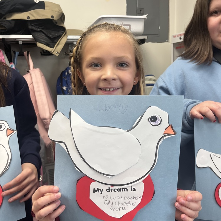 young blonde girl holding blue paper with white dove