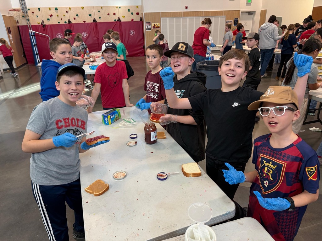 Students making sandwiches and posing for a picture.