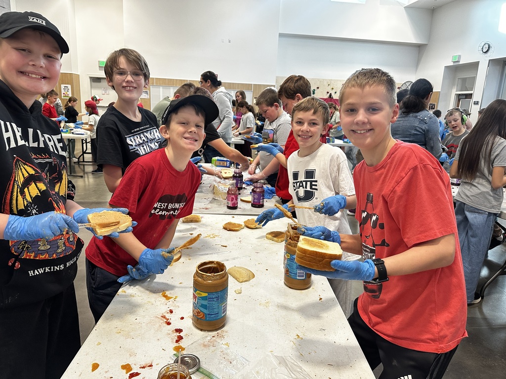 Students making sandwiches and posing for a picture.