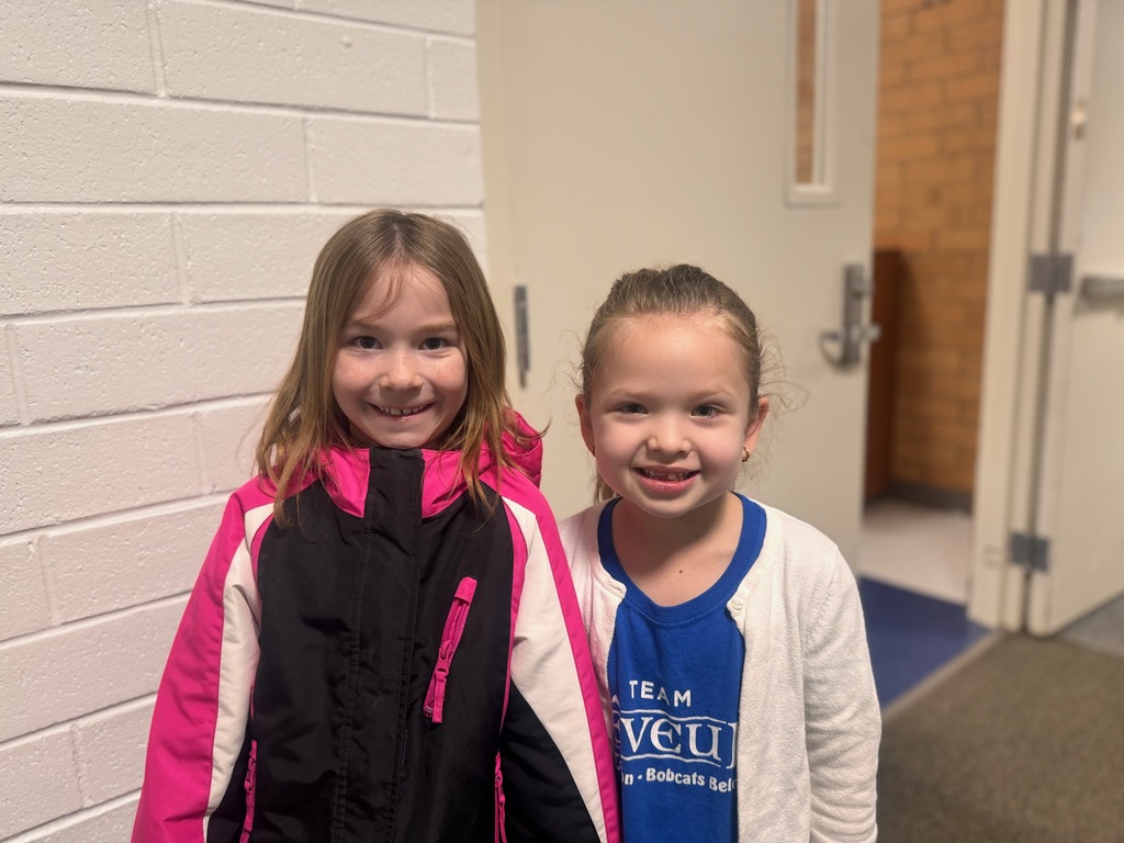 Two students standing in hallway