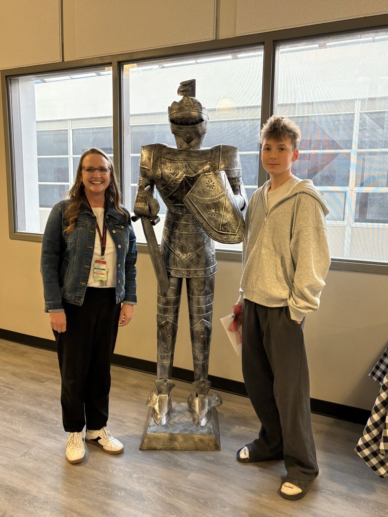 image of a student and teacher standing next to a knight statue.