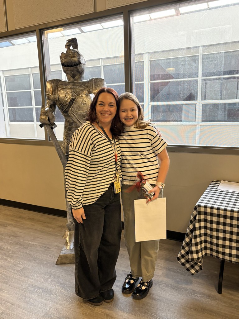 image of a student and teacher standing next to a knight statue.