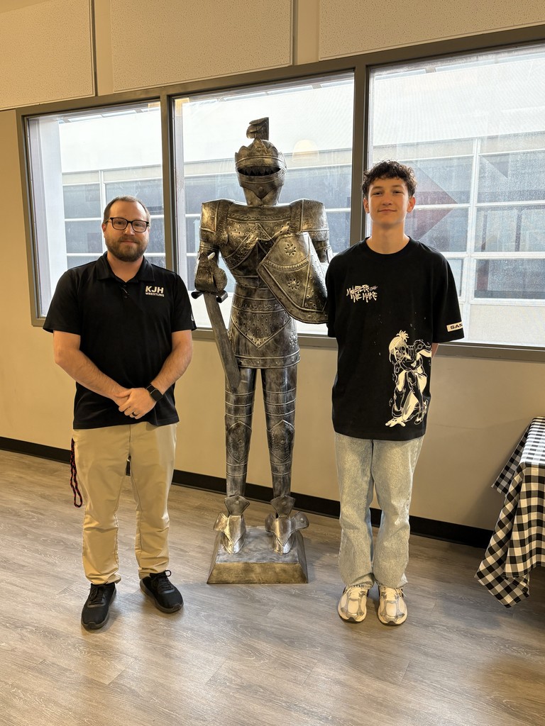 image of a student and teacher standing next to a knight statue.