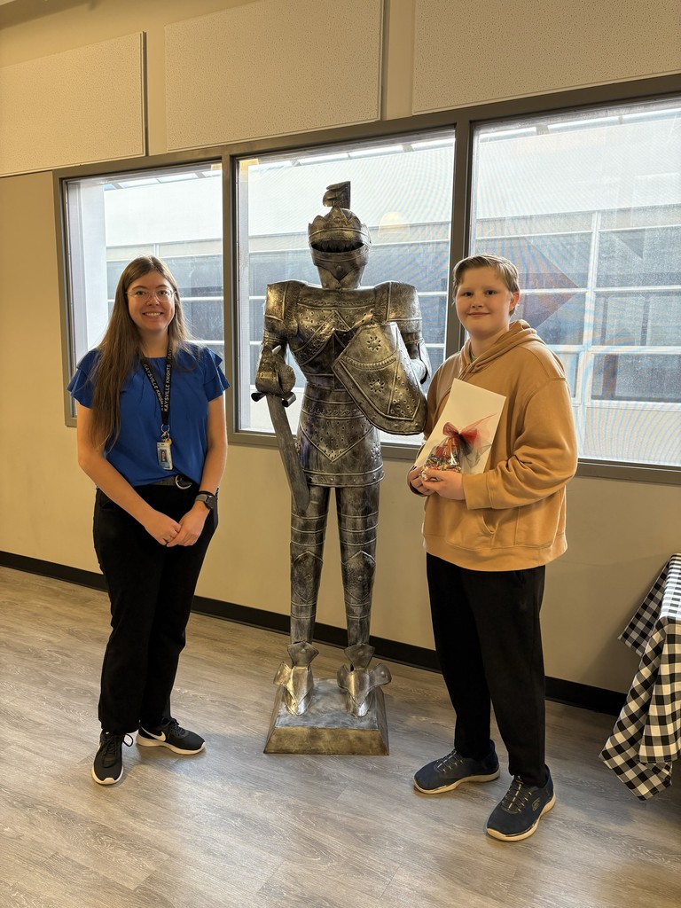 image of a student and teacher standing next to a knight statue.