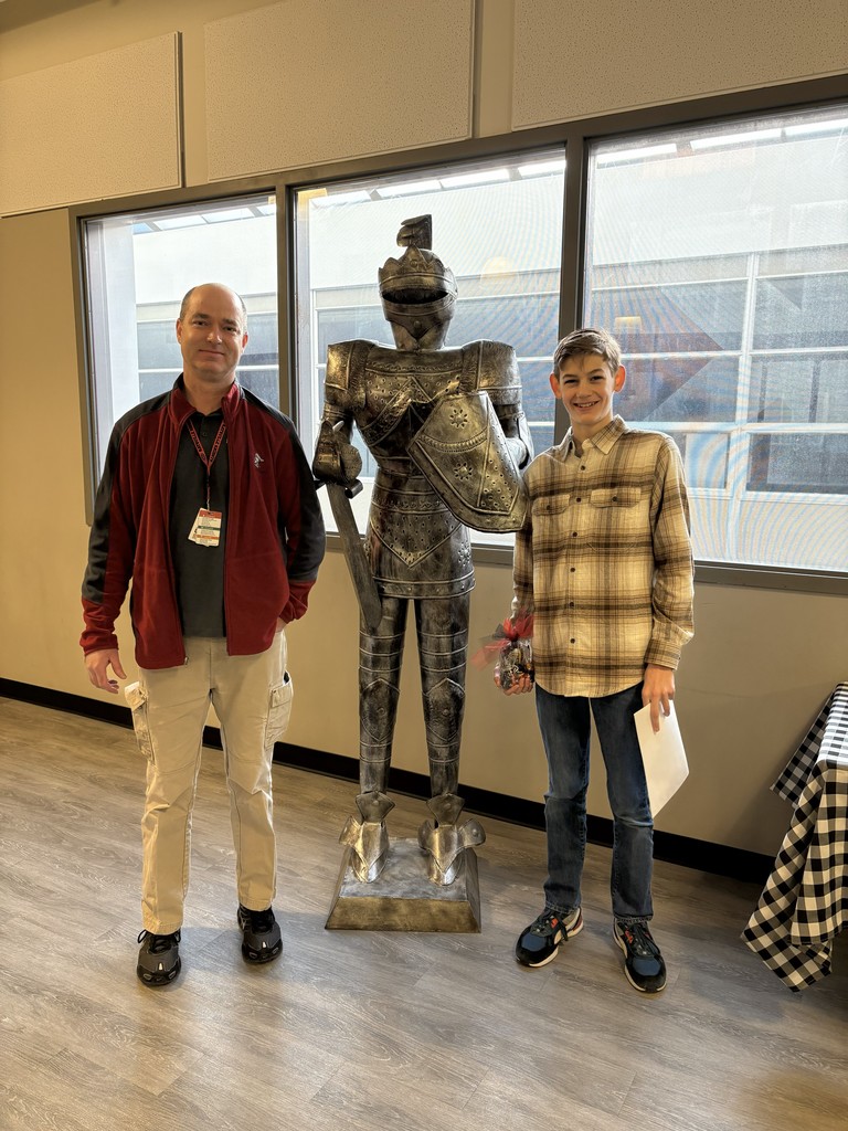 image of a student and teacher standing next to a knight statue.