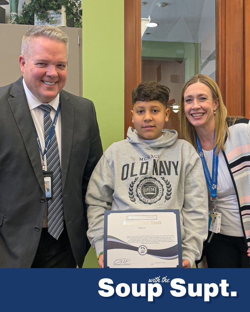 A student holding up a certificate posing with their principal and the superintendent for Soup with the Supt. 