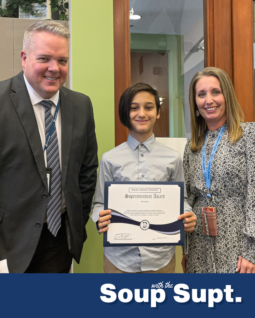 A student holding up a certificate posing with their principal and the superintendent for Soup with the Supt. 