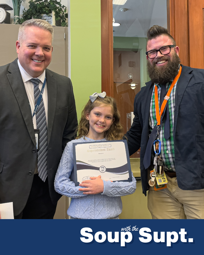 A student holding up a certificate posing with their principal and the superintendent for Soup with the Supt. 
