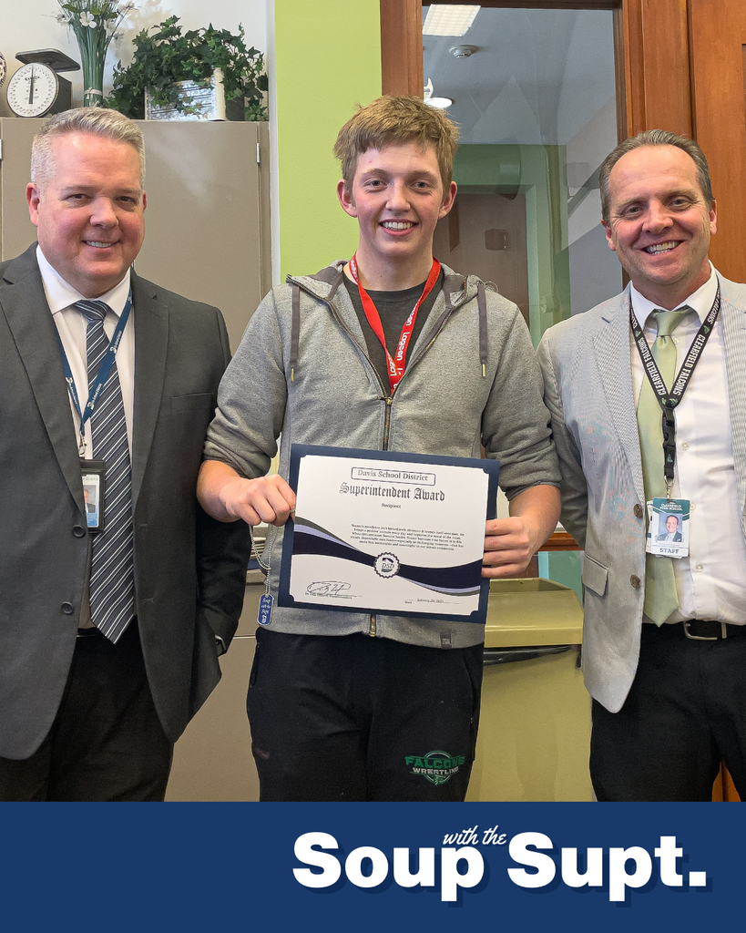 A student holding up a certificate posing with their principal and the superintendent for Soup with the Supt. 
