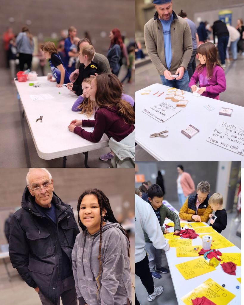 Alt text: A student works independently at a math table while adults and classmates read instructions and discuss the activity.