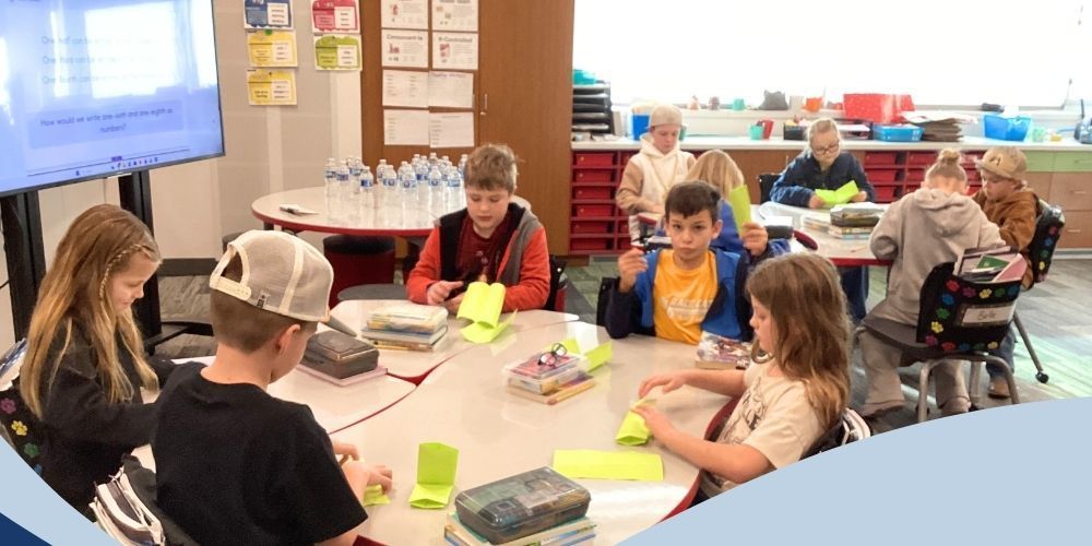Students folding paper at their desks.