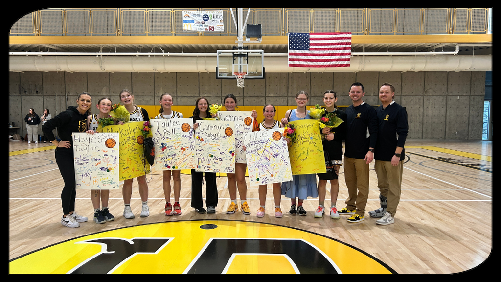 Students and coaches posing for a picture in the gym.