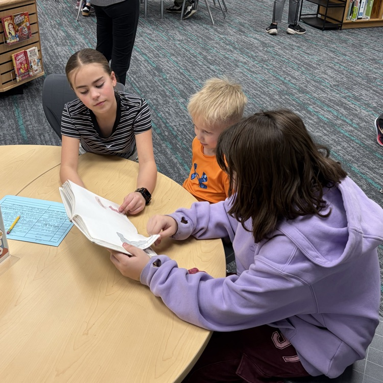Reading buddies! 6th graders and kindergarteners are shown reading together