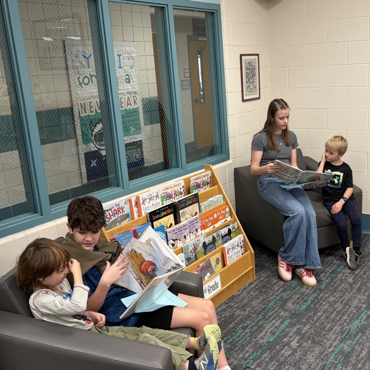 Reading buddies! 6th graders and kindergarteners are shown reading together