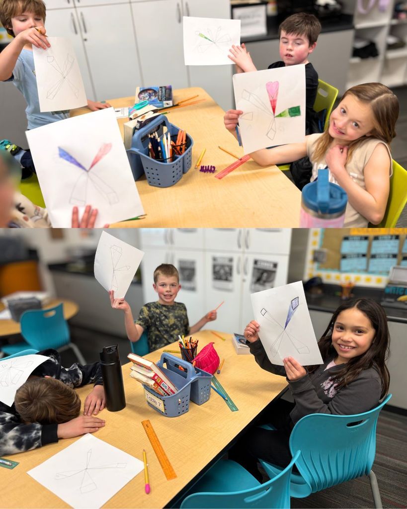 A group of students sit together at a table holding up their 3D shape drawings. Art supplies and water bottles are on the table, and students smile proudly at their work.